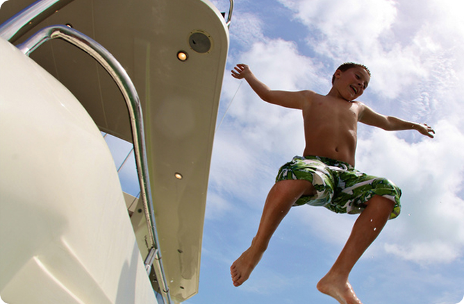 boy jumping out a boat