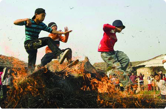 boys jumping over a fire