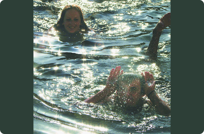 girl swimming behind boy