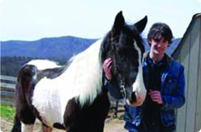 man standing beside of a horse