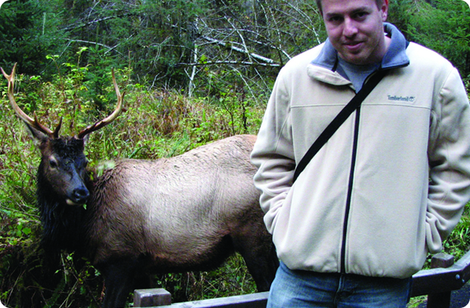 man standing in front of elk