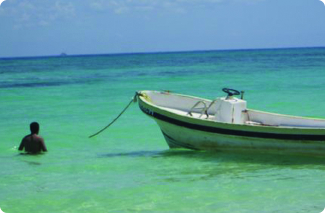 man swimming beside a boat